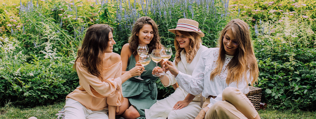 Vier jonge vrouwen lachen tijdens een picknick