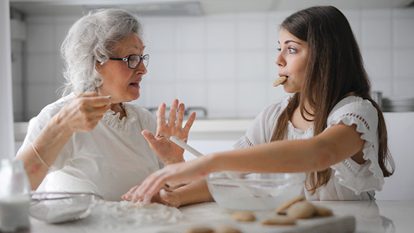 Grootmoeder en kleindochter praten aan keukentafel