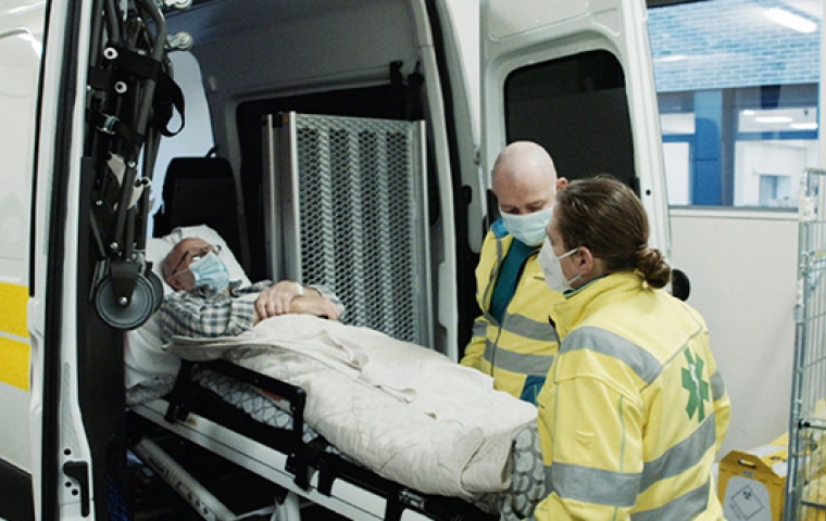 Rudy wordt in ziekenwagen gedragen door ambulanciers