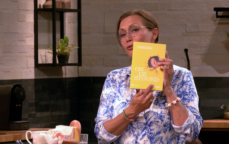 Martine Prenen toont een boek in de studio van TV PLUS