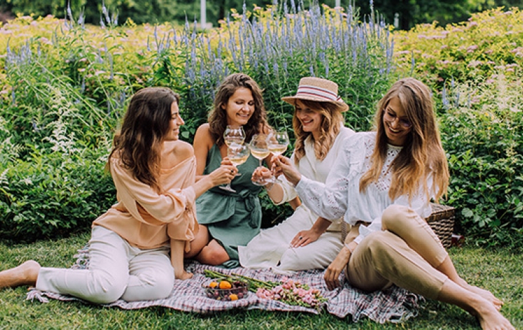 Vier jonge vrouwen lachen tijdens een picknick