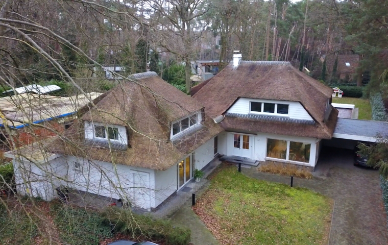 een witte villa met een strooien dak